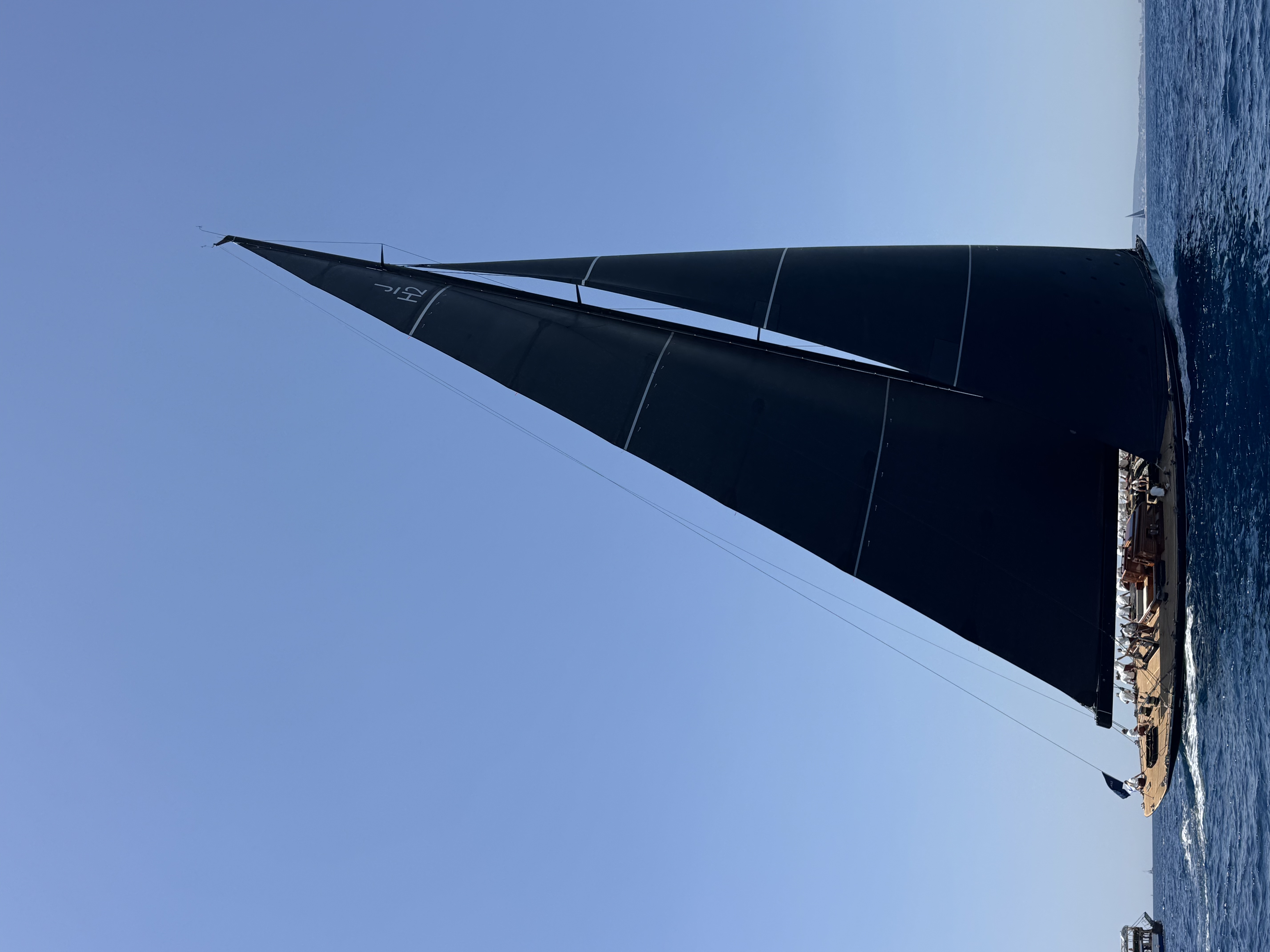Sailing yacht with black sails at sea